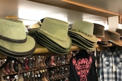A shelf full of western hats.