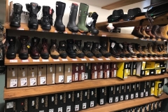A shelf containing workboots and western boots.