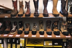 A shelf of both workboots and western boots.